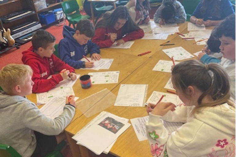 Pupils sat around a table completing an exercise on paper